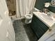 This is a full bathroom with green tile floors, a vanity and a commode at 110 Woodland Ridge Dr, Fuquay Varina, NC 27526