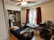 A bedroom with hardwood floors, a bed, and large windows with red curtains at 110 Woodland Ridge Dr, Fuquay Varina, NC 27526