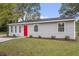 Charming one-story home with gray siding, a bright red front door, and well-manicured landscaping at 1100 Pecan Pl, Durham, NC 27704