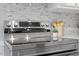 Close-up of sleek stainless steel electric range and backsplash in the updated kitchen at 1100 Pecan Pl, Durham, NC 27704