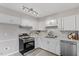 Updated kitchen featuring stainless steel appliances, white cabinets, and modern backsplash at 1100 Pecan Pl, Durham, NC 27704