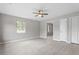 Bright living room featuring stylish light gray walls, wood-look floors, and a modern ceiling fan at 1100 Pecan Pl, Durham, NC 27704