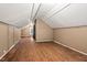Finished attic space with hardwood floors, storage, and neutral colored paneled walls at 1113 Alabama Ave, Durham, NC 27705