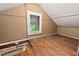 Attic space with hardwood floors, small window and an access panel to another space at 1113 Alabama Ave, Durham, NC 27705