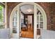 Welcoming foyer with hardwood floors leading to a brick archway with views to the rest of the home at 1113 Alabama Ave, Durham, NC 27705