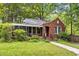 Charming brick home with a well-manicured lawn, flower beds, and a cozy screened-in porch at 1113 Alabama Ave, Durham, NC 27705