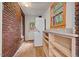 Bright laundry room with exposed brick accent wall, laundry center and built in shelves at 1113 Alabama Ave, Durham, NC 27705