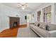 Bright living room showcasing hardwood floors, a brick fireplace, and a stylish neutral sofa at 1113 Alabama Ave, Durham, NC 27705