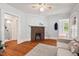 Inviting living room featuring hardwood floors, a brick fireplace, and easy access to the bathroom at 1113 Alabama Ave, Durham, NC 27705
