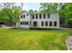 Expansive backyard featuring a lush lawn, modern white home with black-framed windows, and a wooden deck at 112 Meadowbrook Dr, Chapel Hill, NC 27514