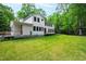 Expansive backyard of modern farmhouse features a large lawn and mature trees at 112 Meadowbrook Dr, Chapel Hill, NC 27514