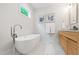 Bright bathroom features a freestanding tub, and a wood double sink vanity at 112 Meadowbrook Dr, Chapel Hill, NC 27514