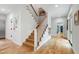 Hallway with hardwood floors and a staircase, featuring a coat closet and access to other rooms at 112 Meadowbrook Dr, Chapel Hill, NC 27514