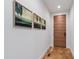 Hallway with hardwood floors, modern art, and a sleek wooden door creating an inviting entrance at 112 Meadowbrook Dr, Chapel Hill, NC 27514