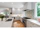 Bright kitchen with white countertops, gray cabinets, and stainless steel appliances, with hardwood flooring at 112 Meadowbrook Dr, Chapel Hill, NC 27514