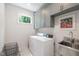 Functional laundry room with a stacked washer and dryer, overhead cabinets, and a stainless steel sink at 112 Meadowbrook Dr, Chapel Hill, NC 27514