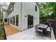 A concrete patio area with an outdoor dining set and grill, complemented by a modern white home exterior at 112 Meadowbrook Dr, Chapel Hill, NC 27514