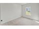 A bright bedroom features neutral carpet, light gray walls, and a window with a view of green grass outside at 121 Cribbs Ln, Middlesex, NC 27557