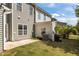 A shot of the property's back yard includes green grass, an AC unit, patio, and lush foliage at 124 Myatt Fern Dr, Garner, NC 27529