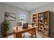 Bright home office features a large desk, custom bookcase, and cozy decor, ideal for remote work or study at 124 Myatt Fern Dr, Garner, NC 27529