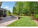 Landscaped backyard featuring a brick patio with outdoor seating and a meticulously maintained lawn at 12428 Penrose Trl, Raleigh, NC 27614