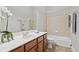 Neutral bathroom with white countertop, vanity and shower-tub combo with tile surround at 12428 Penrose Trl, Raleigh, NC 27614