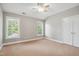 Bright bedroom with neutral walls, two windows with blinds, and a ceiling fan at 12428 Penrose Trl, Raleigh, NC 27614