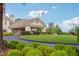 Exterior view of the clubhouse featuring a porte-cochère and beautifully landscaped grounds at 12428 Penrose Trl, Raleigh, NC 27614