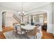 Open-concept dining room flows into living space with a light fixture, and a view of the stairway and front door at 12428 Penrose Trl, Raleigh, NC 27614