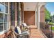 Inviting front porch with comfortable seating, offering a relaxing outdoor space with brick flooring at 12428 Penrose Trl, Raleigh, NC 27614
