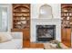 Close up of the living room featuring a fireplace with an intricate mantle, as well as built-in shelving at 12428 Penrose Trl, Raleigh, NC 27614