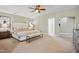 Spacious main bedroom featuring a ceiling fan, neutral color palette, and adjoining bathroom at 12428 Penrose Trl, Raleigh, NC 27614