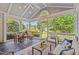 Charming screened porch featuring a high ceiling, outdoor seating, and a view of the landscaped yard, a true outdoor oasis at 12428 Penrose Trl, Raleigh, NC 27614