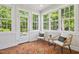 Cozy sun room features brick floors, lots of windows and comfortable seating, ideal for relaxation and enjoying the natural light at 12428 Penrose Trl, Raleigh, NC 27614