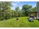 Backyard with green lawn, fire pit, playground equipment, and patio area with pergola and seating at 1302 Ingle Ct, Burlington, NC 27215