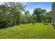 Lush backyard with manicured lawn, mature trees, a cozy pergola, and a fire pit area at 1302 Ingle Ct, Burlington, NC 27215