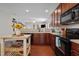 Cozy kitchen with dark cabinets, modern appliances, and an open layout to living area at 1302 Ingle Ct, Burlington, NC 27215