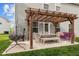 View of the cozy back patio showcasing a pergola, dining set, hanging chair, and outdoor seating at 1302 Ingle Ct, Burlington, NC 27215