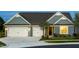 Charming home showcasing a two-car garage, tasteful landscaping, and welcoming front entrance with exterior lighting at 1601 Garden Park Cir, Fuquay Varina, NC 27526