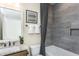 Modern bathroom featuring a tub, shower, granite countertop, decorative mirror, and stylish fixtures at 1605 Garden Park Cir, Fuquay Varina, NC 27526