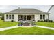 Backyard featuring patio, fire pit with seating, and manicured lawn at 1609 Garden Park Cir, Fuquay Varina, NC 27526