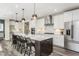 Modern eat-in kitchen with white cabinets, marble counters, and bar stool seating at 1609 Garden Park Cir, Fuquay Varina, NC 27526