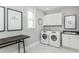 Functional laundry room featuring white cabinets, modern washer and dryer, and folding counter at 1609 Garden Park Cir, Fuquay Varina, NC 27526