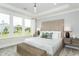Bright main bedroom featuring a large window, tray ceiling, and stylish furnishings at 1609 Garden Park Cir, Fuquay Varina, NC 27526