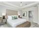 Bright main bedroom featuring a large upholstered headboard, tray ceiling, and stylish furnishings at 1609 Garden Park Cir, Fuquay Varina, NC 27526