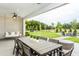 Covered patio seating area with hanging swing, dining table, and backyard fire pit at 1609 Garden Park Cir, Fuquay Varina, NC 27526