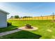 Spacious backyard featuring a manicured lawn, firepit, and wood fence at 1610 Garden Park Cir, Fuquay Varina, NC 27526