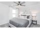 Bright bedroom with large window, plush bed, and a modern ceiling fan at 1610 Garden Park Cir, Fuquay Varina, NC 27526