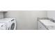 Laundry area with modern washer and dryer, along with a granite countertop sink at 1610 Garden Park Cir, Fuquay Varina, NC 27526