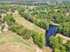 Aerial view of the community with a golf course, pond and mature trees at 1913 Wild Dunes Dr, Raleigh, NC 27604